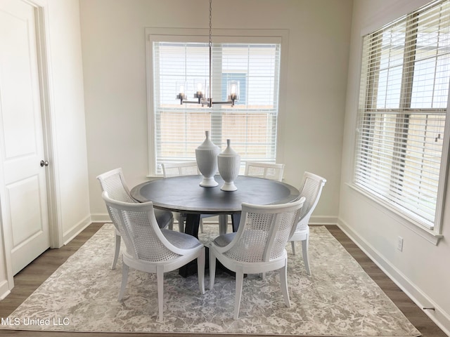 dining space with a chandelier and dark hardwood / wood-style flooring