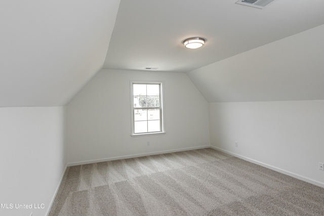 additional living space featuring vaulted ceiling and carpet floors