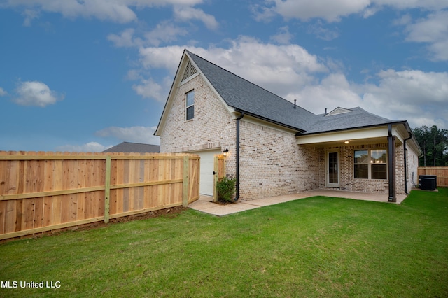 back of house featuring central air condition unit, a patio, and a lawn