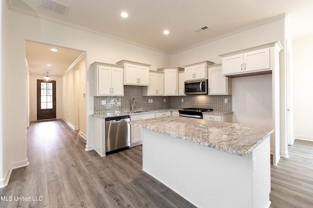 kitchen featuring a kitchen island, appliances with stainless steel finishes, white cabinetry, light hardwood / wood-style floors, and sink