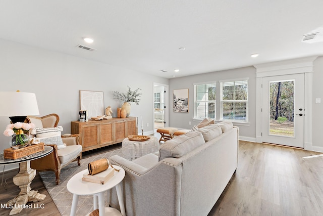 living area featuring baseboards, visible vents, and light wood-type flooring