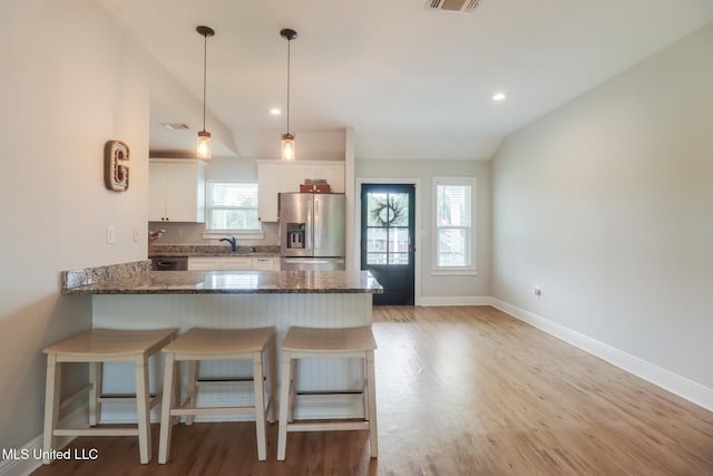 3927 Washington Ave, Gulfport, MS 39507 - kitchen featuring stainless steel fridge with ice dispenser, vaulted ceiling, light wood-type flooring, baseboards, and dark stone counters