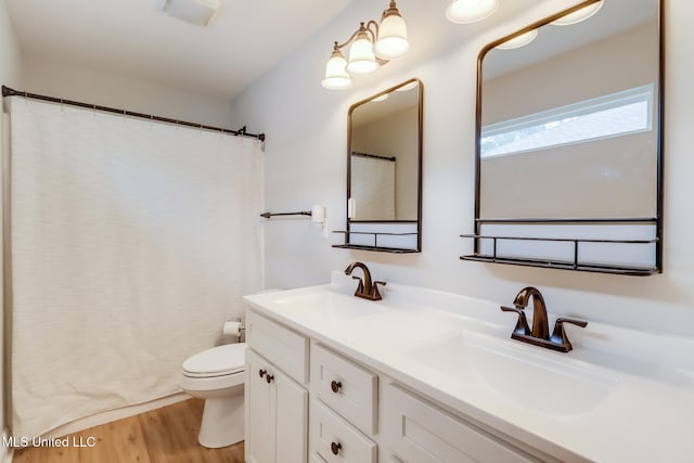 3927 Washington Ave, Gulfport, MS 39507 - full bath with toilet, double vanity, wood finished floors, and curtained shower