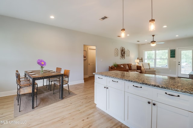 3927 Washington Ave, Gulfport, MS 39507 - kitchen with light wood-style floors, ceiling fan, white cabinetry, stone countertops, and baseboards