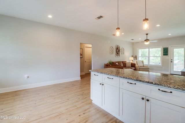 3927 Washington Ave, Gulfport, MS 39507 - kitchen with light wood-type flooring, ceiling fan, white cabinetry, baseboards, and stone countertops