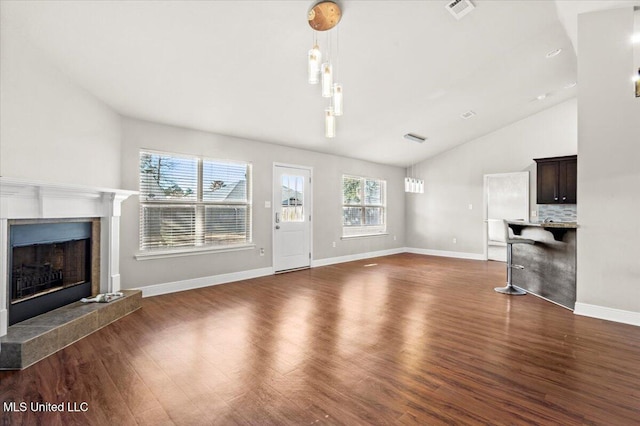 unfurnished living room with dark wood-type flooring, a fireplace, and high vaulted ceiling