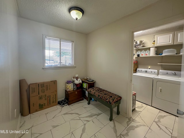 laundry area with washer and dryer and a textured ceiling