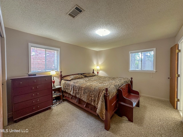 bedroom with a textured ceiling and carpet