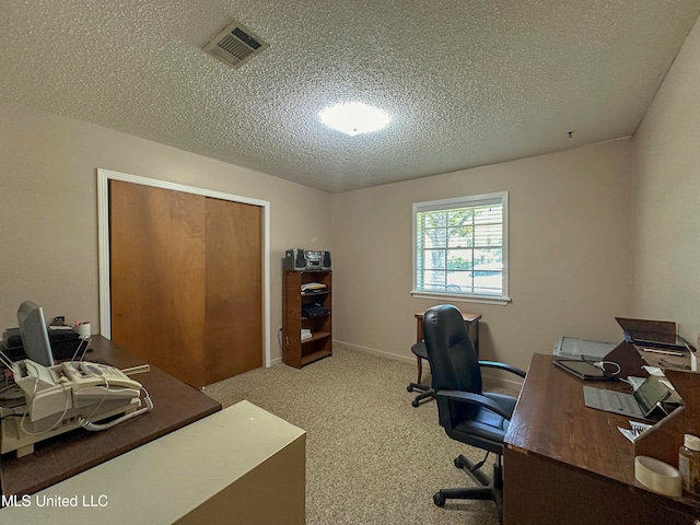 carpeted office space featuring a textured ceiling