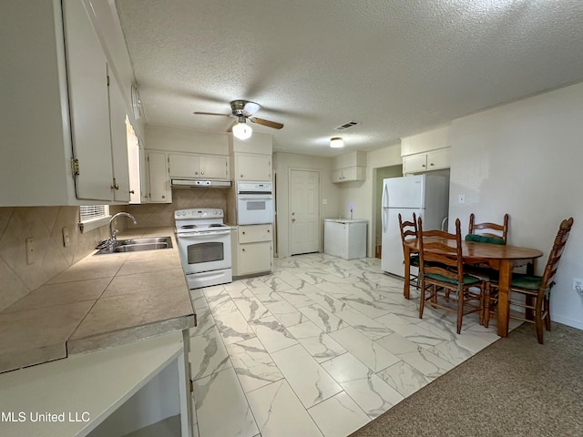 kitchen with backsplash, sink, white cabinets, white appliances, and ceiling fan