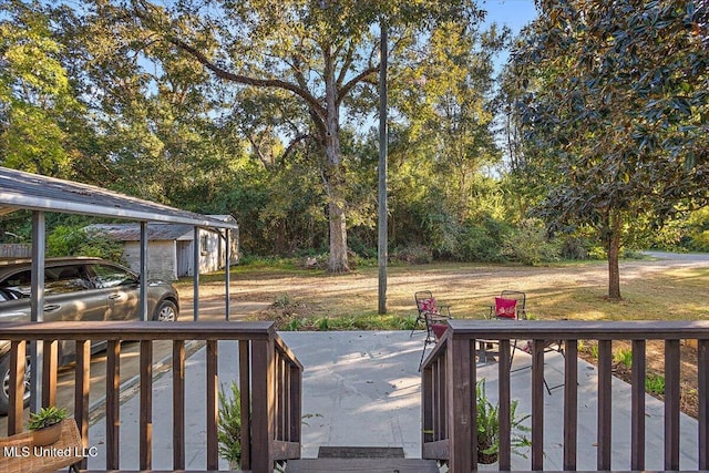 view of yard with a wooden deck and a carport