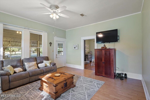 living room with ceiling fan, ornamental molding, a wealth of natural light, and hardwood / wood-style floors