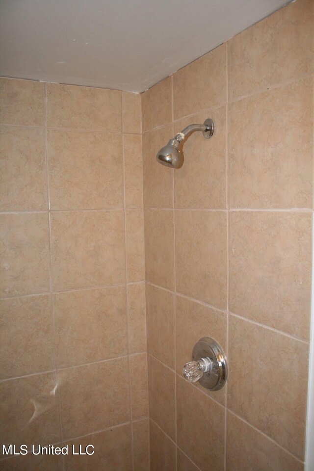 interior details with a tile shower