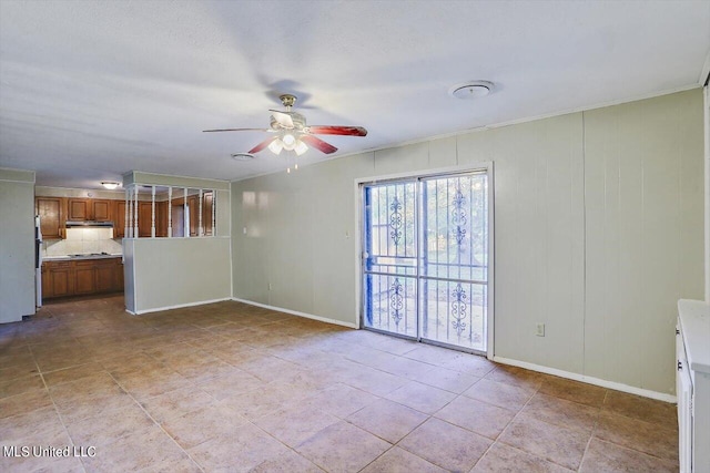 spare room with ornamental molding and ceiling fan