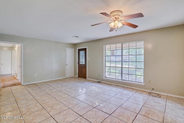 tiled spare room with ceiling fan