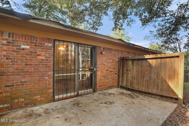338 Lake Of Pines Dr, Jackson, MS 39206 - doorway to property with brick siding, fence, and a patio area