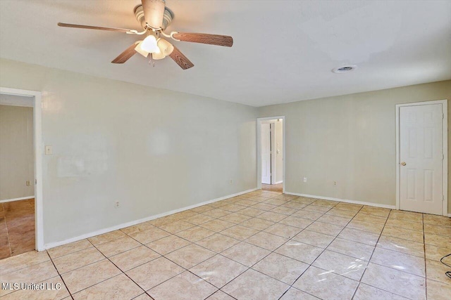 tiled spare room with ceiling fan