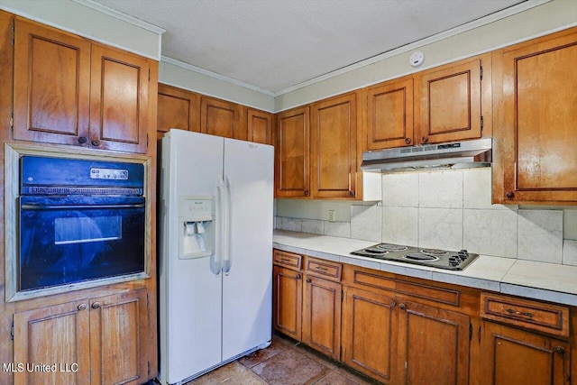 kitchen featuring decorative backsplash, black oven, crown molding, stainless steel cooktop, and white refrigerator with ice dispenser