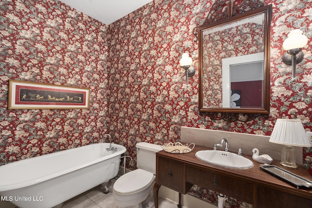 bathroom with toilet, a tub to relax in, vanity, and tile patterned floors