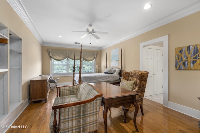 bedroom with ceiling fan, crown molding, and wood-type flooring