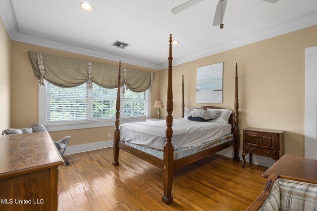 bedroom featuring hardwood / wood-style floors, crown molding, and ceiling fan