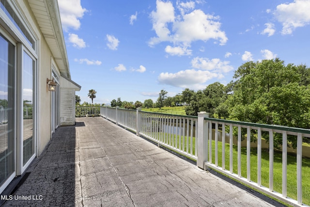 view of patio featuring a water view and a balcony