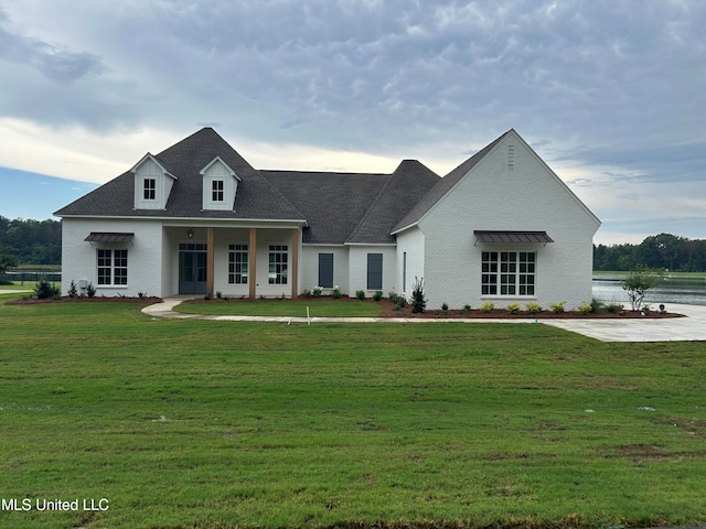 view of front of property with a front lawn and a water view