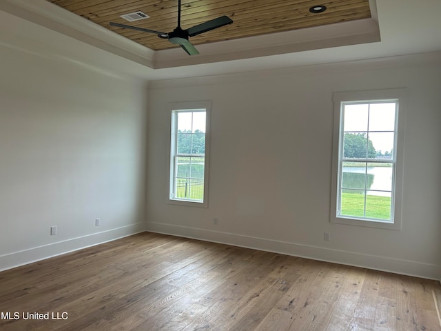 spare room with light hardwood / wood-style floors, a raised ceiling, wood ceiling, and ceiling fan