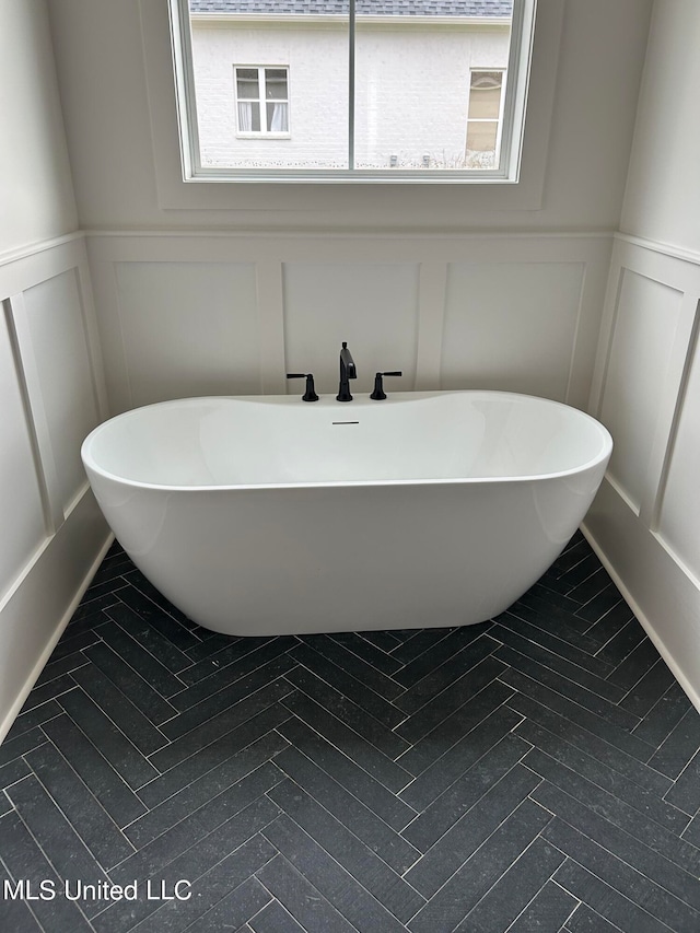 bathroom with a healthy amount of sunlight, sink, and a bathtub