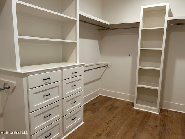 walk in closet with dark hardwood / wood-style floors