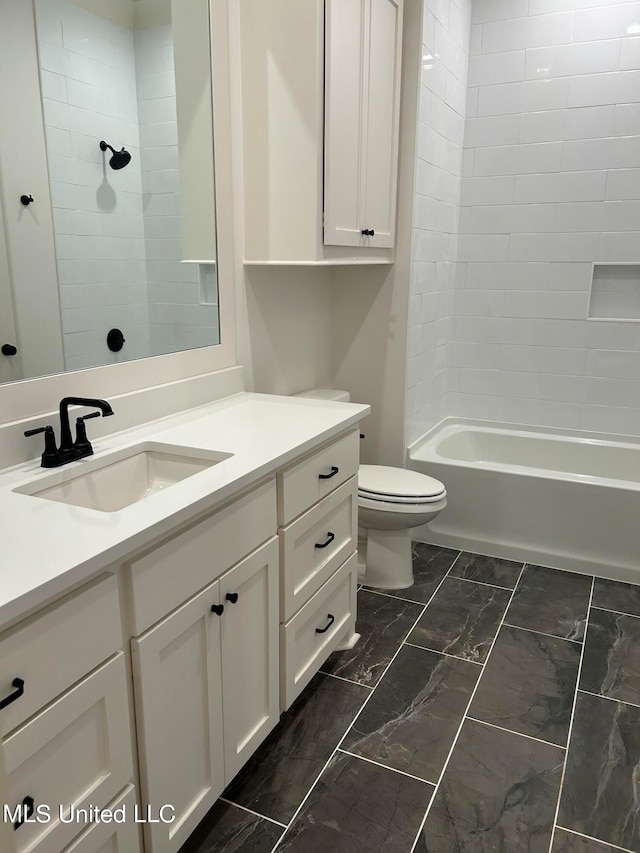 full bathroom with tiled shower / bath, vanity, and toilet