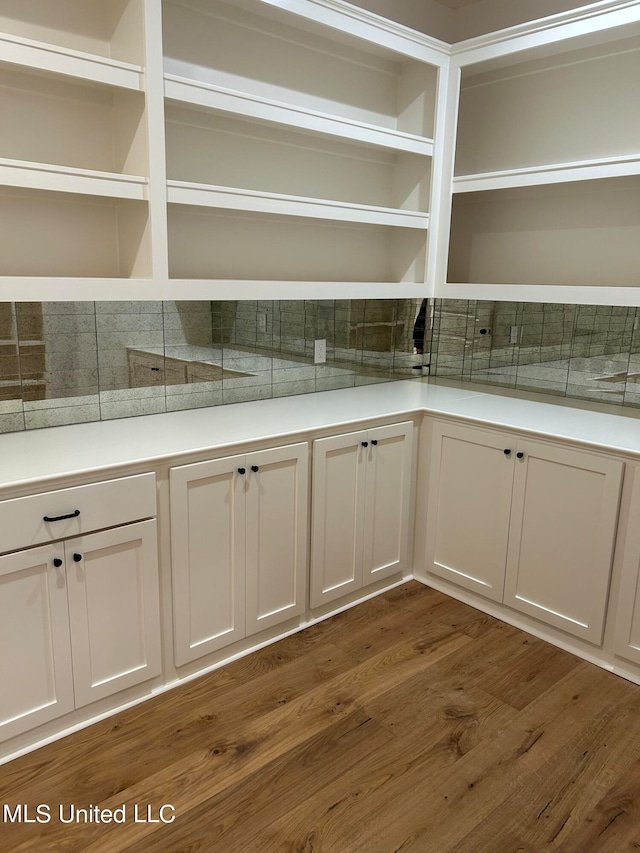 interior space featuring white cabinets, dark hardwood / wood-style floors, and tasteful backsplash