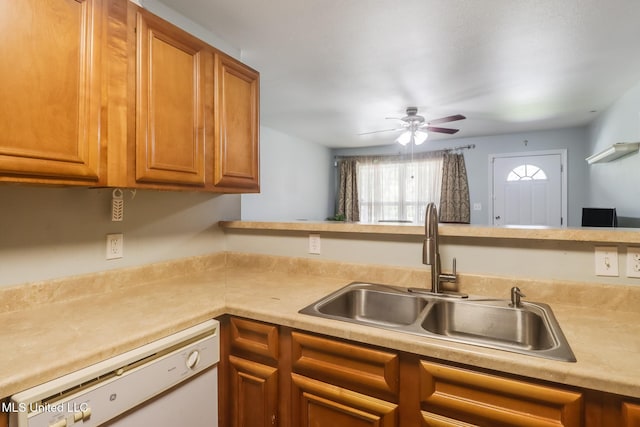 kitchen with light countertops, brown cabinetry, white dishwasher, and a sink