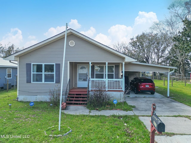 view of front facade with a front lawn, central air condition unit, concrete driveway, covered porch, and a carport