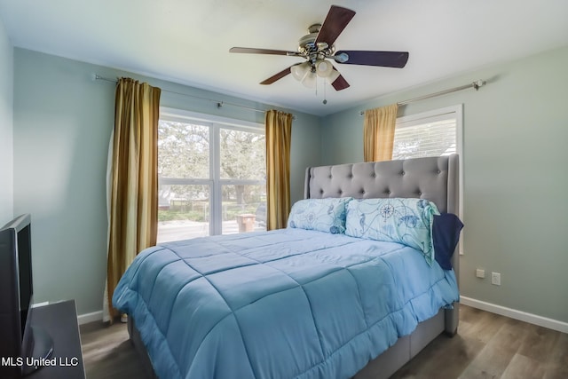 bedroom featuring wood finished floors, baseboards, and ceiling fan