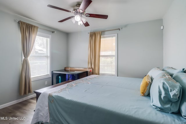 bedroom featuring ceiling fan, baseboards, and wood finished floors