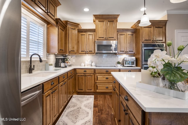 23 Callaway Ct, Hattiesburg, MS 39402 - kitchen with stainless steel appliances, a sink, brown cabinetry, ornamental molding, and dark wood-style flooring