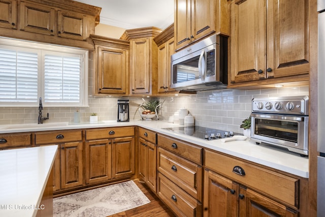 23 Callaway Ct, Hattiesburg, MS 39402 - kitchen featuring stainless steel microwave, black electric cooktop, a sink, backsplash, and crown molding