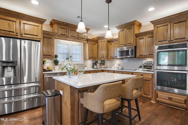 23 Callaway Ct, Hattiesburg, MS 39402 - kitchen with stainless steel appliances, brown cabinetry, a center island, light countertops, and decorative backsplash