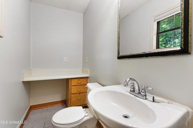 20 Yorkshire Pkwy, Gulfport, MS 39503 - bathroom featuring a textured ceiling, toilet, baseboards, tile patterned flooring, and a sink