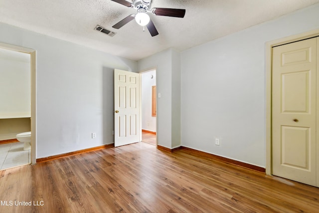 20 Yorkshire Pkwy, Gulfport, MS 39503 - unfurnished bedroom featuring baseboards, wood finished floors, ensuite bath, a textured ceiling, and a ceiling fan