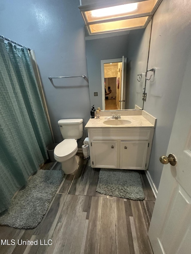 713 Hawthorn Green Dr, Ridgeland, MS 39157 - bathroom featuring wood finished floors, vanity, toilet, a shower with curtain, and baseboards