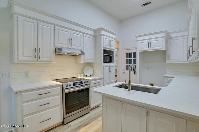 kitchen with appliances with stainless steel finishes, sink, light stone counters, and white cabinets