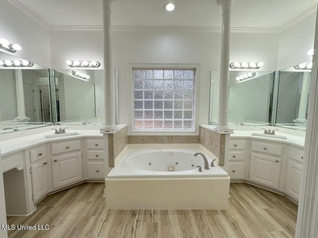 bathroom with a bath, vanity, wood-type flooring, and ornamental molding