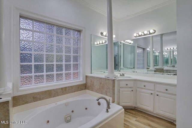 bathroom featuring vanity, a relaxing tiled tub, hardwood / wood-style flooring, and ornamental molding