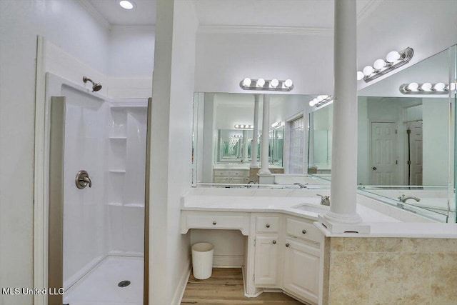 bathroom featuring walk in shower, wood-type flooring, vanity, and ornamental molding