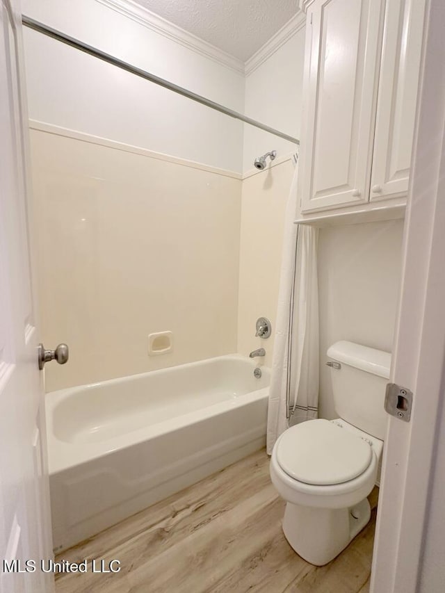 bathroom with wood-type flooring, ornamental molding, a textured ceiling, shower / tub combo, and toilet