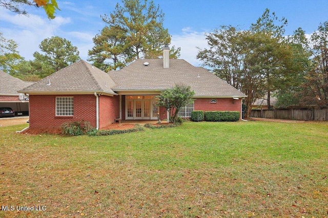 back of house with french doors and a lawn