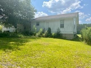rear view of house featuring a yard