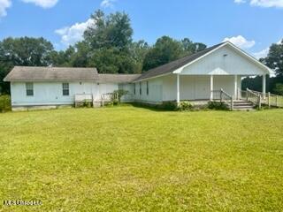 rear view of property featuring a yard
